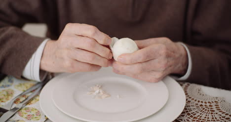 Old-Man-Peeling-Egg-On-Plate-2