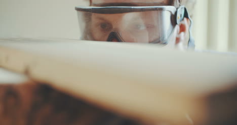 Carpenter-In-Protective-Glasses-Examining-Wood-1