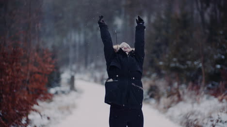 Positive-Woman-Jumping-On-Snow-And-Playing-With-Scarf-In-Winter-3