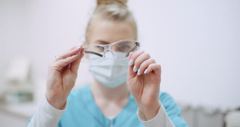 Ärztin-Mit-Schutzmaske-Im-Gesicht-Und-Brillenputzerin-In-Der-Gesundheitsklinik