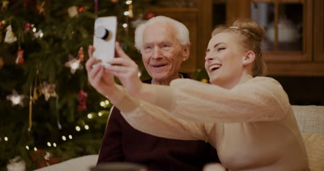 Fröhliche-Frau-Macht-Selfie-Mit-Großvater-Zu-Weihnachten-3