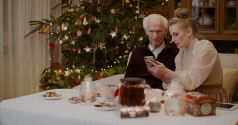 Frau-Lehrt-Großvater-Zu-Weihnachten-Handy-Zu-Benutzen