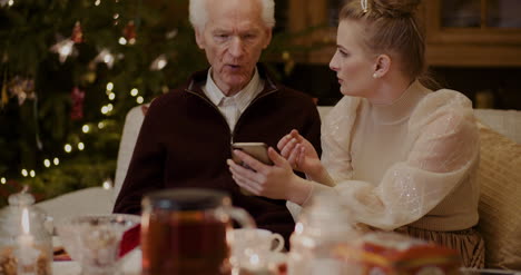 Frau-Lehrt-Großvater,-Smartphone-Zu-Weihnachten-Zu-Benutzen-2
