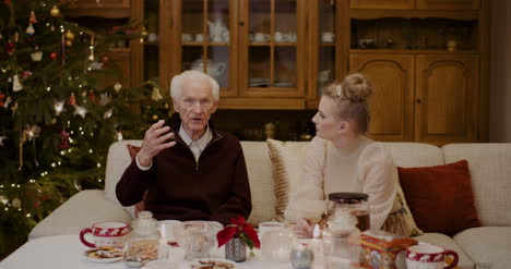 Frau-Im-Gespräch-Mit-Großvater-Zu-Hause-Während-Der-Weihnachtszeit