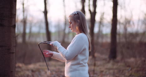 Woman-Uses-A-Stethoscope-And-Examines-A-Tree-In-The-Forest