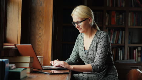 Mujer-Trabaja-Con-Laptop-En-Biblioteca