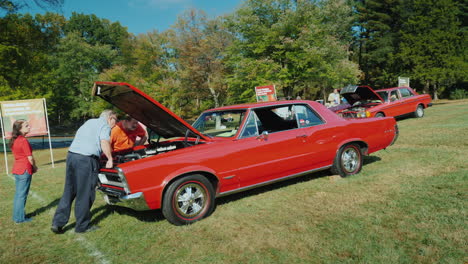 Enthusiasten-Untersuchen-Klassisches-Rotes-Auto