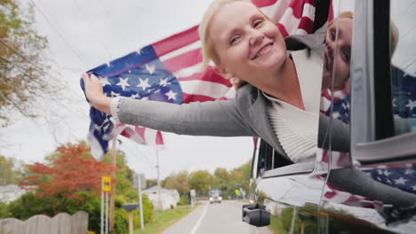 Frau-Lehnt-Sich-Mit-USA-Flagge-Aus-Dem-Auto