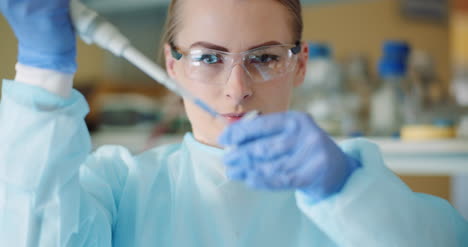Female-Scientist-With-Pipette-Analyzes-Liquid-At-Laboratory