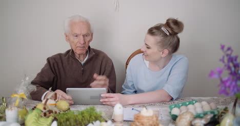 Old-Man-Retirement-Smiling-Senior-Man-Talking-With-Granddaughter-While-Using-Digital-Tablet-1