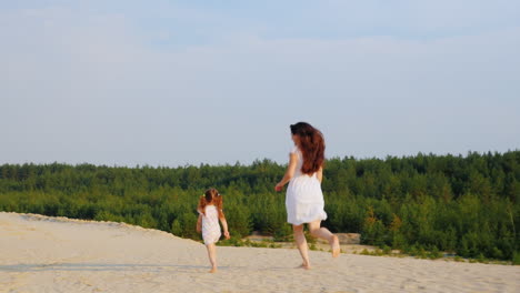 Mom-Plays-With-Her-Daughter-Run-In-The-Sand-Back-View