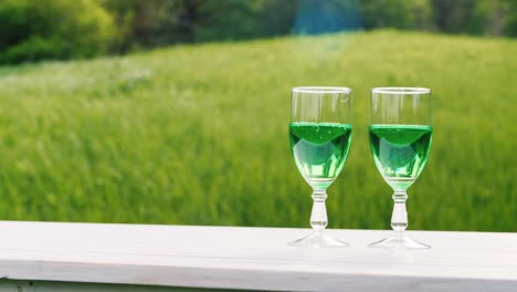 Two-Glasses-With-Green-Lemonade-On-A-Background-Of-A-Green-Lawn-In-A-Spring-Garden