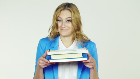 A-Young-Woman-Holding-A-Stack-Of-Books-Embarrassment-UlybaetsyaVideo-Photographed-In-The-Studio-On-A