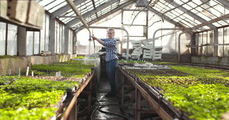 Female-Farmer-Watering-Plants-In-Greenhouse-Agriculture