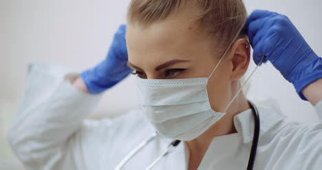 Female-Doctor-Putting-On-Protective-Mask-At-Clinic-1
