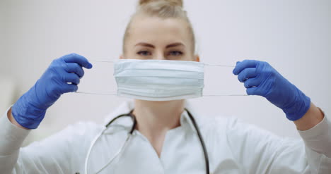 Female-Doctor-Putting-On-Protective-Mask-At-Clinic-2
