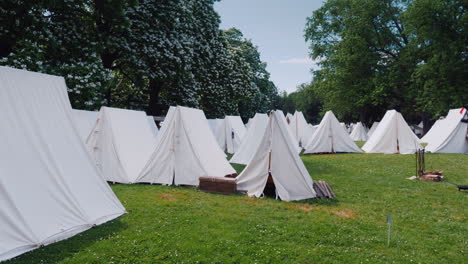 An-Old-Military-Camp-Rows-Of-Tents-Stand-In-The-Forest-Reconstruction-Of-The-Times-Of-The-Wars-With