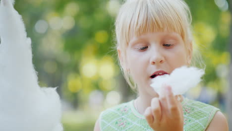 The-Girl-Is-Eating-Delicious-Sweet-Cotton-Wool-In-The-Park-Licks-His-Fingers-Out-4k-Video