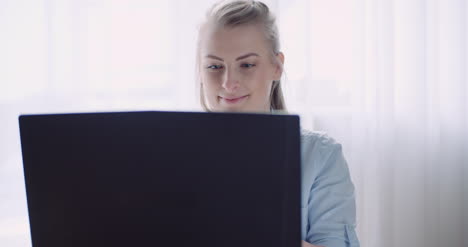Lächelnde-Frau-Arbeitet-Am-Laptop-Zu-Hause-Im-Büro
