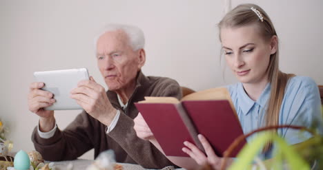 Young-Woman-Surfing-Internet-With-Grandfather-On-Digital-Tablet-2