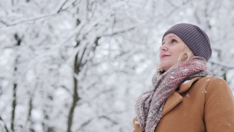 Low-Angle-Shot-Of-Middle-Aged-Woman-Admires-Winter-Forest-4k-Video