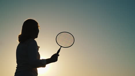 Junge-Frau-Spielt-Badminton-Bei-Sonnenuntergang-Aktiver-Urlaub-Im-Freien-Spielekonzept-4k-Videok