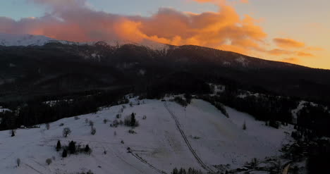 Luftaufnahme-Von-Schneebedeckten-Bergen-Und-Wäldern-Bei-Sonnenuntergang-Im-Winter-6