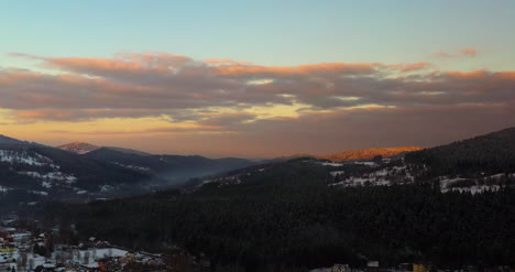 Luftaufnahme-Von-Schneebedeckten-Bergen-Und-Wäldern-Bei-Sonnenuntergang-Im-Winter-8