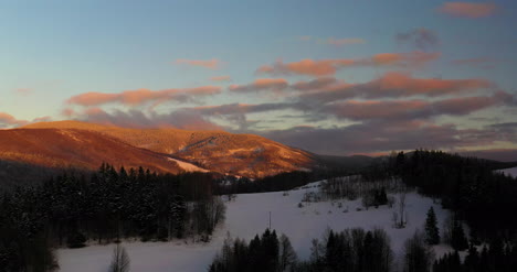 Luftaufnahme-Von-Schneebedeckten-Bergen-Und-Wäldern-Bei-Sonnenuntergang-Im-Winter-10