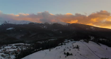 Aerial-View-Of-Mountains-And-Forest-Covered-With-Snow-At-Sunset-In-Winter-2