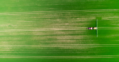 Agriculture-Aerial-Of-Tractor-Spraying-Farm-Land-With-Pesticides