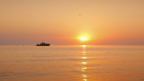 Ein-Einsames-Fischerboot-Segelt-Bei-Sonnenuntergang-Am-Meer-4k-Video