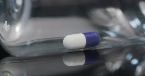 Einzelne-Medizinische-Pille-In-Kleiner-Flasche,-Die-Auf-Schwarzem-Hintergrund-Dreht-8
