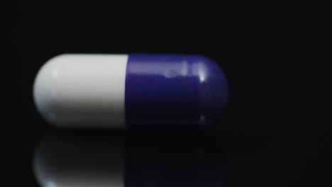 Einzelne-Medizinische-Pille-Rotiert-Auf-Schwarzem-Hintergrund