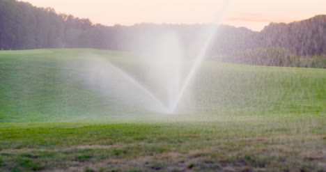 Medium-Shot-Of-Grass-Sprinkler-Splashes-Water-Over-The-Lawn