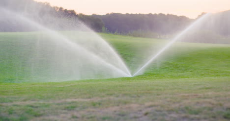 Medium-Shot-Of-Grass-Sprinkler-Splashes-Water-Over-The-Lawn-1