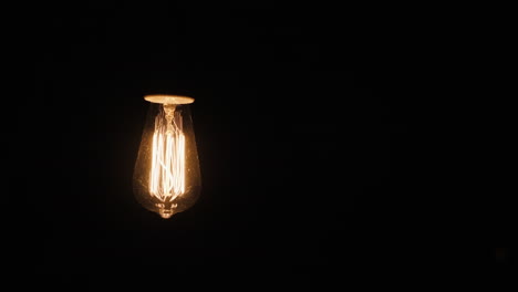 Edisons-Lampe-Leuchtet-Im-Dunklen-Hintergrund-Mit-Elektrischen-Lamas-4k-Video