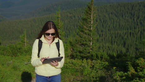 Junge-Frau-Genießt-Ein-Smartphone-Vor-Einer-Malerischen-Kulisse-Von-Bergen,-Die-Immer-Mit-Wald-Bedeckt-Sind-Covered