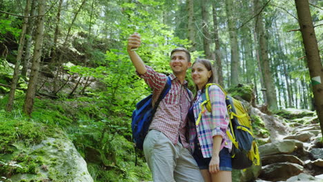 An-Attractive-Couple-Of-Tourists-Are-Photographed-In-The-Forest-Selfie-With-Backpacks-On-A-Hike-4K-V