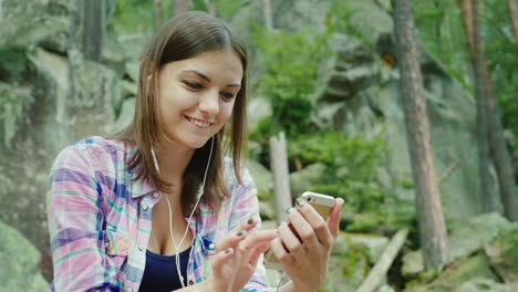 Eine-Junge-Touristin-Benutzt-Ein-Smartphone-Bei-Einer-Wanderung-Und-Ruht-Sich-Gegen-Die-Felsen-In-Den-Bergen-Aus-4k