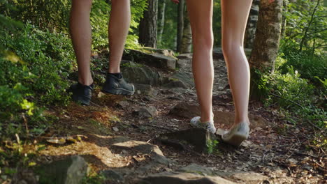 A-Pair-Of-Travelers-Walk-Along-A-Narrow-Mountain-Path-In-The-Forest-In-The-Frame-Only-The-Legs-Are-V