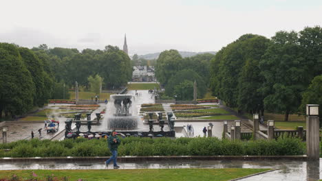 Skulpturenpark-Gustav-Vigeland-Regenwetter-Viele-Touristen-Gehen-Unter-Den-Sonnenschirmen-Im-Park