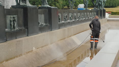 The-Worker-Cleans-The-Fountain-In-The-Sculpture-Park-Of-Gustav-Vigeland