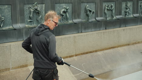 The-Worker-Cleans-The-Fountain-In-The-Sculpture-Park-Of-Gustav-Vigeland