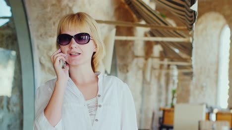 Mujer-Turista-Hablando-Por-Teléfono-En-El-Fondo-De-Un-Restaurante-Italiano-Típico