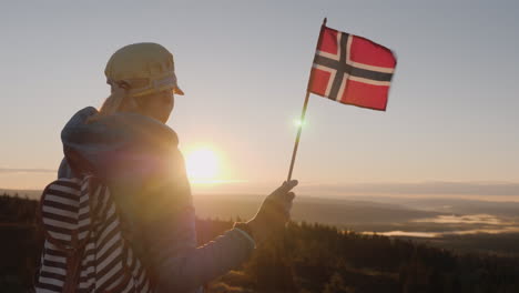 Ein-Reisender-Mit-Der-Norwegischen-Flagge-In-Der-Hand-Trifft-Den-Sonnenaufgang-Auf-Dem-Gipfel-Des-Berges