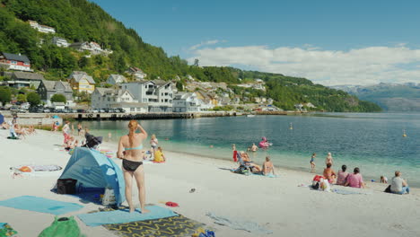 Tourists-Bathing-And-Resting-On-A-Small-Beach-Amidst-A-Picturesque-Fjord