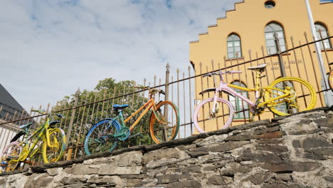 Mehrere-Bunte-Fahrräder-Stehen-Am-Zaun-Originelle-Dekoration-In-Der-Stadt