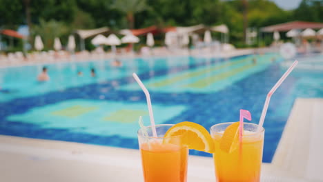 Ein-Luxuriöser-Urlaub-Für-Zwei-Liebhaber-Zwei-Gläser-Mit-Einem-Orangencocktail-Auf-Dem-Hintergrund-Eines-Riesigen-P