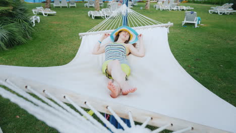A-Bright-Girl-In-Cool-Colored-Clothes-And-A-Broad-Brimmed-Hat-Is-Resting-On-The-Sea-Coast-In-A-White